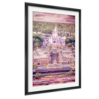 A framed aerial view of a castle-like structure with multiple towers and turrets, surrounded by a colorful and whimsical landscape.