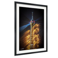 a tall tower with a pointed top and a spire, surrounded by a display of colorful lights and sparks, creating a visually striking and dynamic scene.