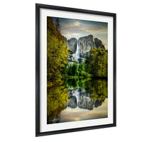 a serene landscape with a large waterfall cascading down a rocky cliff, surrounded by lush green trees and reflected in a calm lake below.