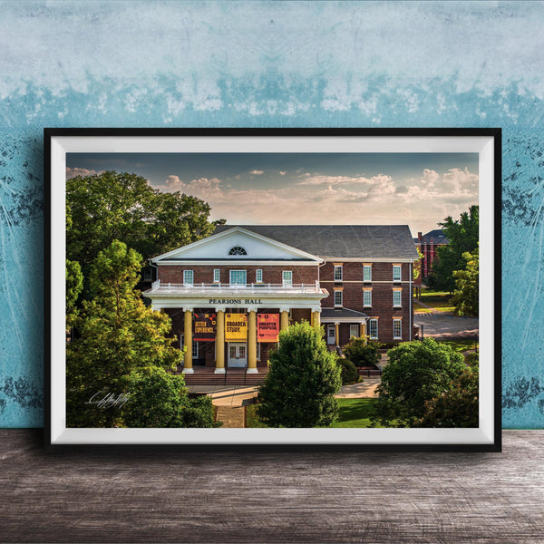 A framed photograph of the Peabody Hall building, a historic brick structure with a prominent pediment and columns, surrounded by trees and a blue sky.