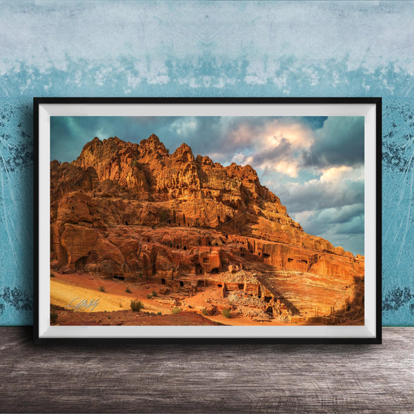 a large, rocky cliff with a dramatic sky in the background.
