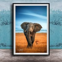 A majestic elephant stands in a golden field, its large ears flapping gently in the breeze, with a lion standing nearby.