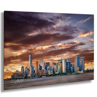 a city skyline at sunset, with the tall buildings silhouetted against a dramatic sky filled with clouds and warm hues.