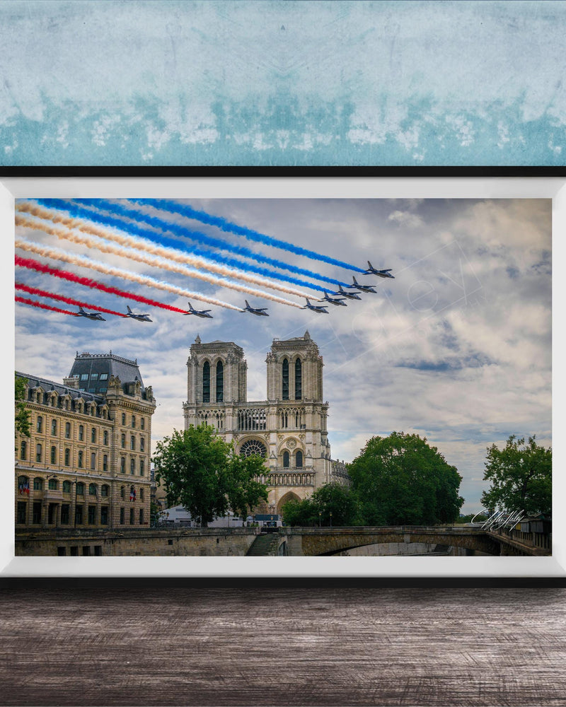A framed photograph of the French Air Force performing a military air show, with fighter jets flying in formation and leaving trails of smoke in the sky. The backdrop is the iconic Notre-Dame Cathedral in Paris.