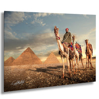 A man rides a camel in front of the iconic pyramids of Giza, Egypt, with a cloudy sky in the background.