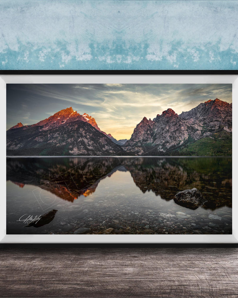 a serene mountain landscape with a calm lake reflecting the mountains and sky.
