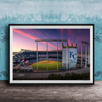 A framed photograph of a baseball stadium at sunset, with the Kansas City Royals logo prominently displayed.