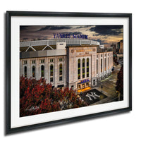A framed photograph of Yankee Stadium, a baseball stadium located in New York City, with the iconic New York Yankees logo prominently displayed on the front of the building.