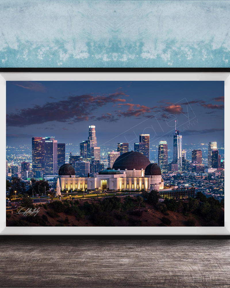 A framed photograph of the Los Angeles skyline at night, with the Griffith Observatory prominently featured in the foreground.