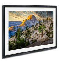 a breathtaking mountain landscape with a large, snow-capped peak in the distance, surrounded by a lush forest and a dramatic sky with vibrant colors.