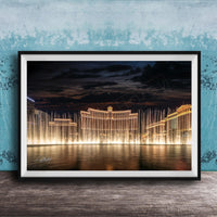 A framed photograph of the Bellagio Fountains in Las Vegas at night, with the fountains illuminated and creating a stunning reflection on the water surface.