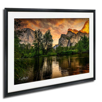 a serene landscape with a river reflecting the vibrant colors of the sky and surrounding mountains.