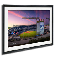 A framed photograph of a baseball stadium at sunset, with the Kansas City Royals logo visible on the outfield wall.