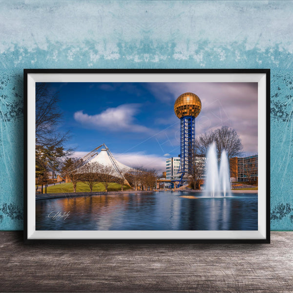 A framed photograph of the iconic Space Needle in Nashville, Tennessee, with a fountain in the foreground and a blue sky with clouds in the background.