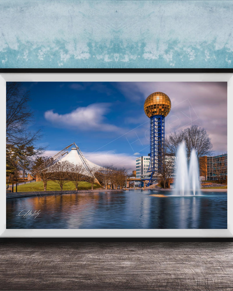 A framed photograph of the iconic Space Needle in Nashville, Tennessee, with a fountain in the foreground and a blue sky with clouds in the background.