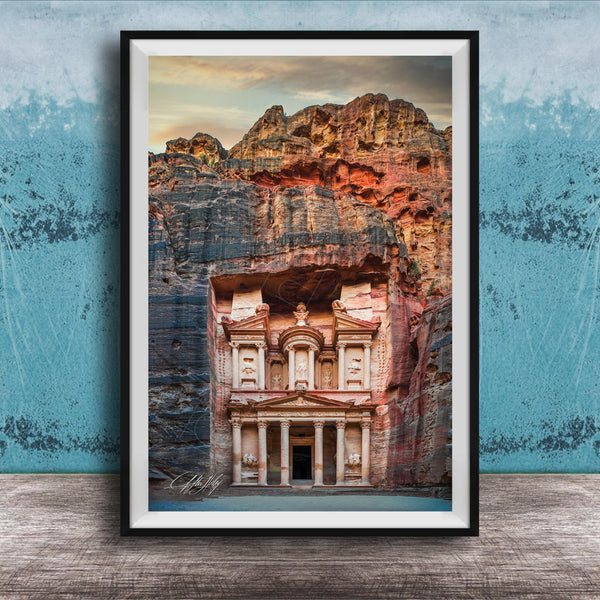 A framed image of the ancient Monastery carved into a cliff face, with a dramatic sky and rocky landscape in the background.