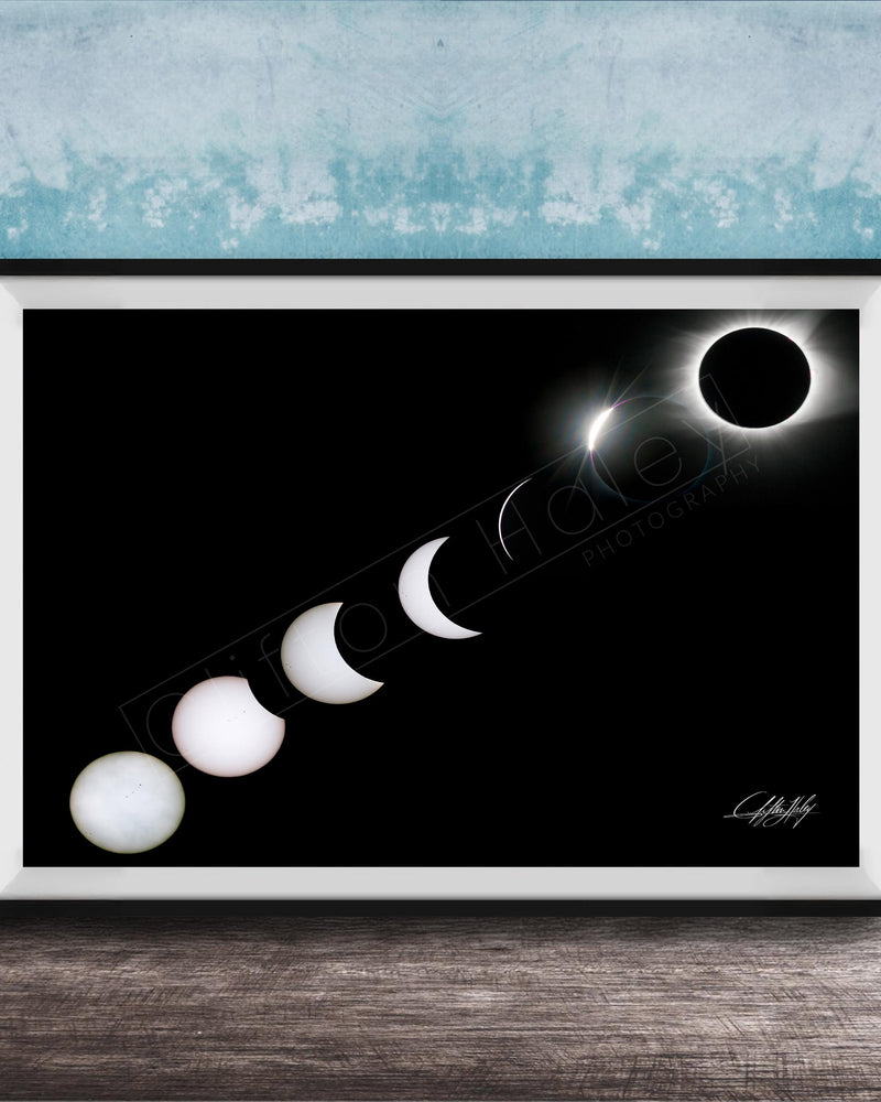 A framed image depicting the solar eclipse, showing the moon transitioning from a crescent to a full moon, with the sun partially obscured by the moon.