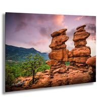 a striking natural landscape with towering rock formations, a lone tree, and a dramatic sky with clouds.