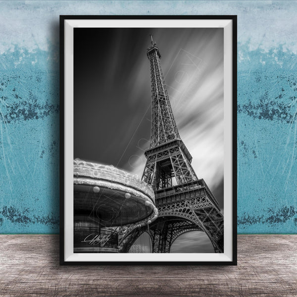 A black and white photograph of the Eiffel Tower in Paris, France, with a blurred background.