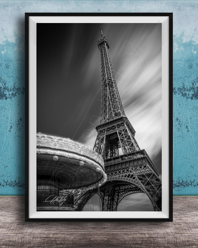 A black and white photograph of the Eiffel Tower in Paris, France, with a blurred background.