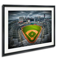 An aerial view of a baseball stadium with a baseball field, surrounded by a city skyline.