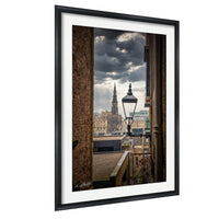 a cityscape with a tall, ornate building in the background, framed by a black border.