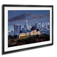 A framed photograph of the Los Angeles skyline at night, featuring the Griffith Observatory and surrounding buildings illuminated against a dark sky.