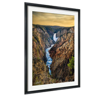 A framed photograph depicting a stunning waterfall cascading down a steep, rocky cliff face with a vibrant sky in the background.