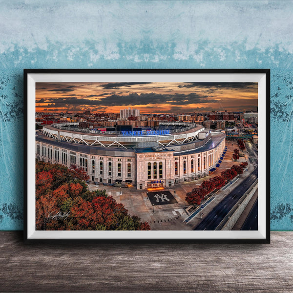 The image is a framed photograph of the Yankee Stadium in New York City, with a stunning sunset in the background.
