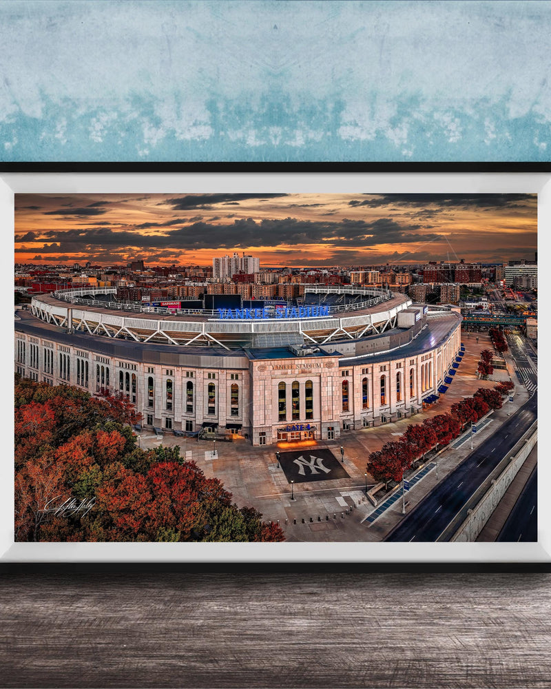 The image is a framed photograph of the Yankee Stadium in New York City, with a stunning sunset in the background.