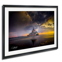 a castle on a beach, with a dramatic sky and sunset in the background.