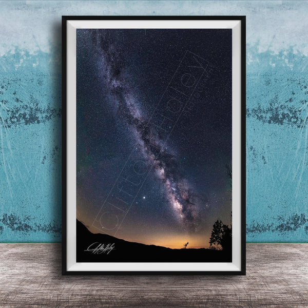 The image is a framed photograph of a night sky with the Milky Way galaxy, a stunning celestial display.