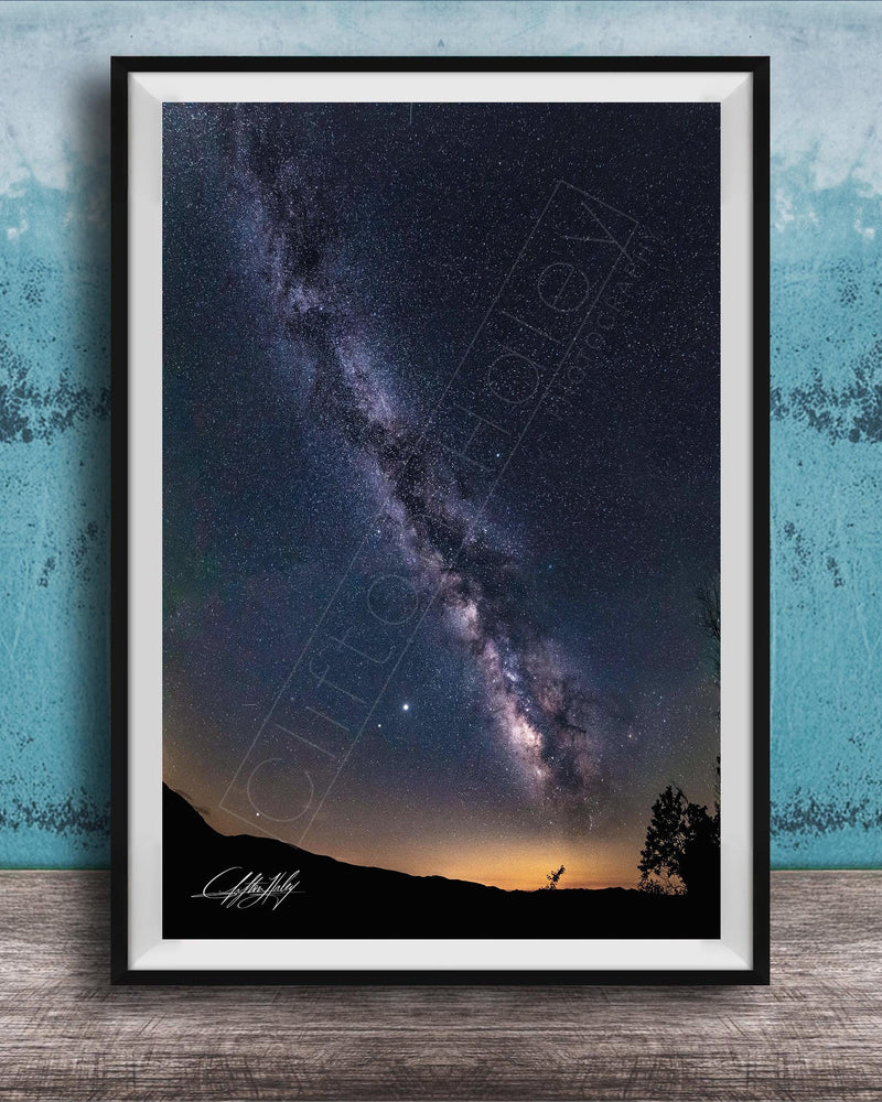 The image is a framed photograph of a night sky with the Milky Way galaxy, a stunning celestial display.
