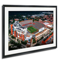An aerial view of a large sports stadium with a football field, surrounded by buildings and other structures.