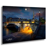 a picturesque night scene of a bridge illuminated by lights, with a full moon in the sky and a cathedral spire in the background.