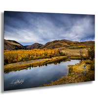 a serene landscape with a calm lake surrounded by mountains and trees with autumn foliage.