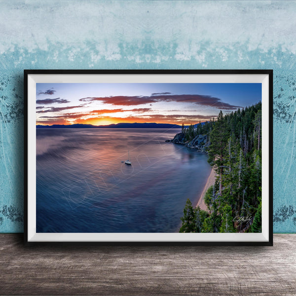 A framed photograph depicting a serene landscape with a calm lake, a boat on the water, and a forested shoreline in the background.