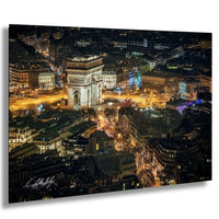 a cityscape at night, featuring a large, illuminated archway surrounded by buildings and illuminated by the city lights.
