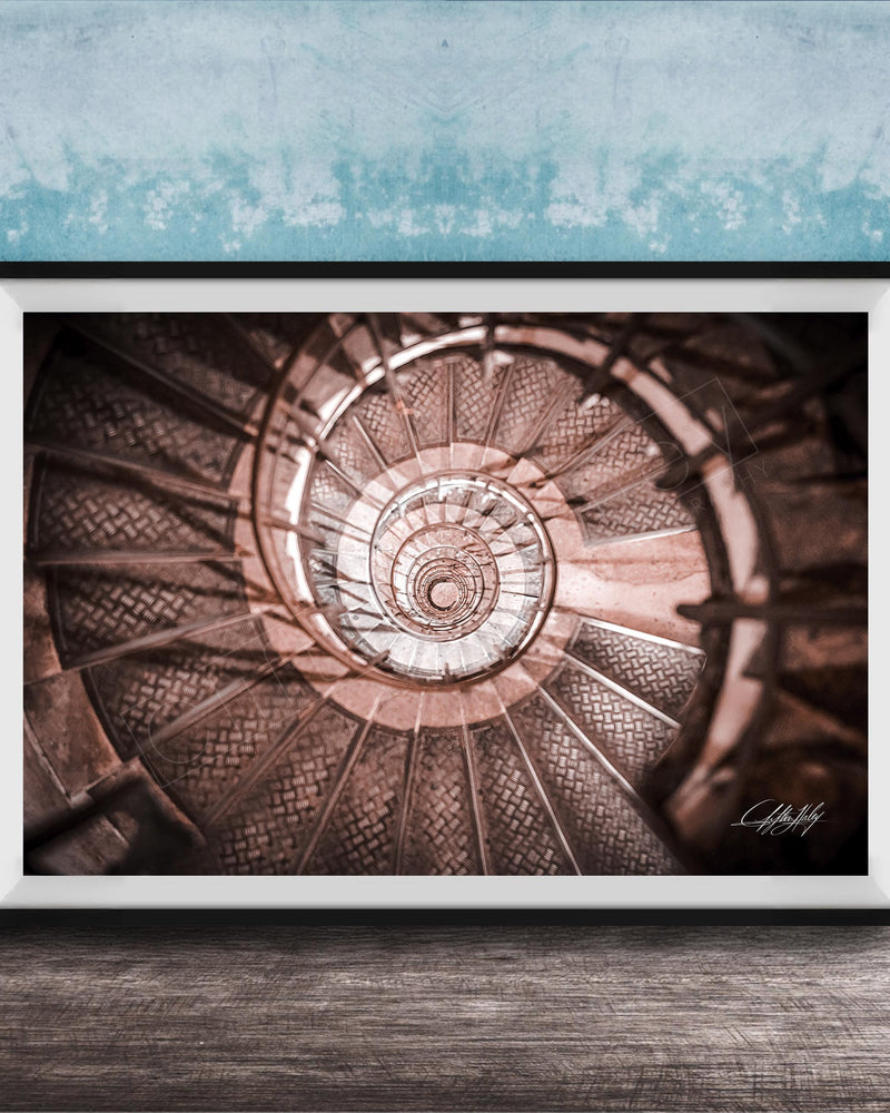 The image is a framed photograph of a spiral staircase, with the steps arranged in a spiral pattern and the image captured from a low angle.