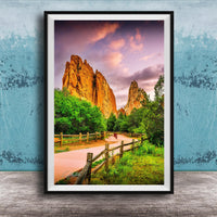 A framed photograph of a scenic landscape with towering rock formations, a wooden fence, and a vibrant sky with clouds.