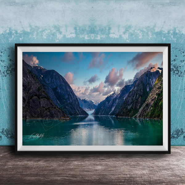 The image is a framed photograph of a serene mountain lake, with a stunning view of the mountains and the calm waters reflecting the sky.