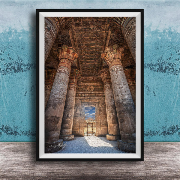 an ancient Egyptian temple with towering columns and intricate carvings, set against a blue wall with a textured pattern.