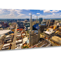 The image is an aerial view of a bustling city skyline, showcasing a mix of tall buildings, skyscrapers, and other structures. The cityscape is dotted with numerous windows and glass panels, reflecting the bright sunlight. The sky above is a clear blue, with a few scattered clouds. The image is a collage of multiple images, capturing different angles and perspectives of the city's architectural diversity.
