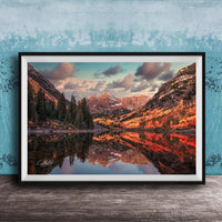 The image is a framed photograph depicting a scenic mountain landscape with a lake reflecting the mountains and trees.