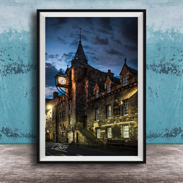 a historic stone building with a clock tower, set against a dark sky with clouds.