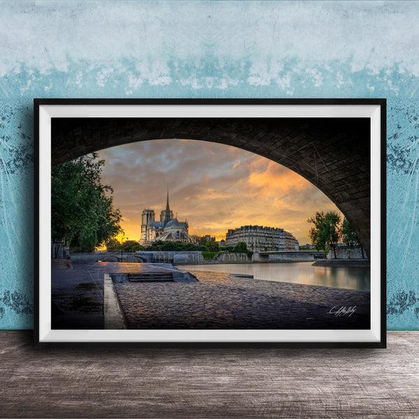 a serene cityscape at sunset, with a large cathedral in the background and a stone bridge arching over a river. The sky is filled with warm, golden hues, creating a picturesque and tranquil atmosphere.