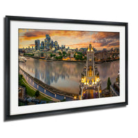 The image is a framed photograph of the London skyline at sunset, featuring the iconic Tower Bridge and the River Thames.