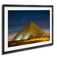 a large pyramid illuminated at night, with a bright star visible in the sky above it.