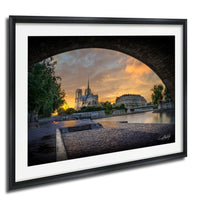 a picturesque view of a cityscape, with a large cathedral in the background and a bridge arching over a river in the foreground. The sky is filled with warm, vibrant colors, creating a serene and peaceful atmosphere.