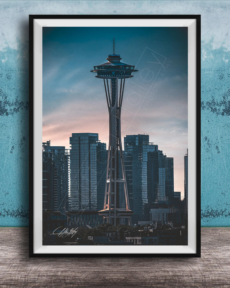 A framed photograph of the Space Needle, a famous landmark in Seattle, Washington, with the city skyline in the background.